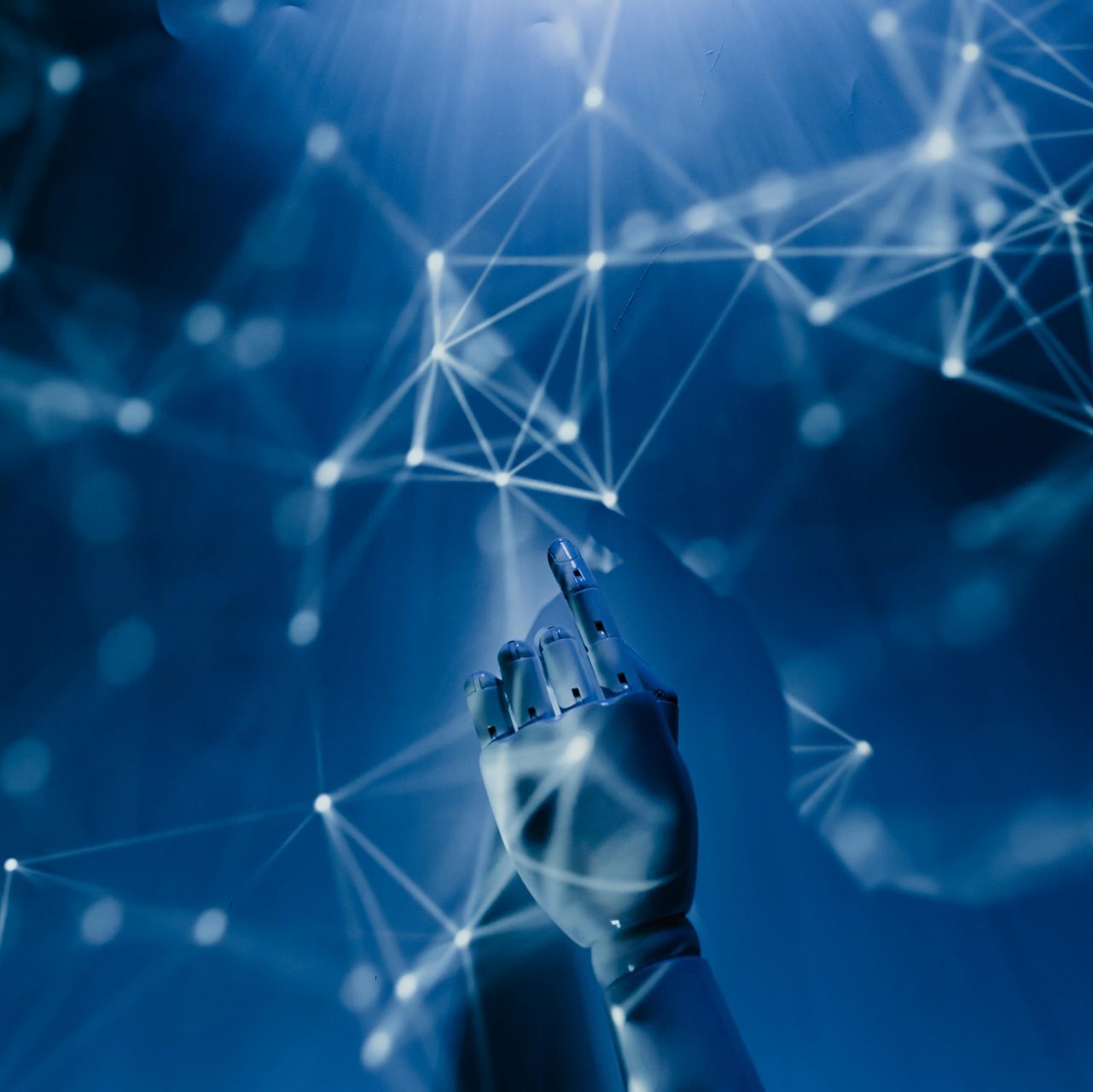 A robotic hand reaching into a digital network on a blue background, symbolizing AI technology.